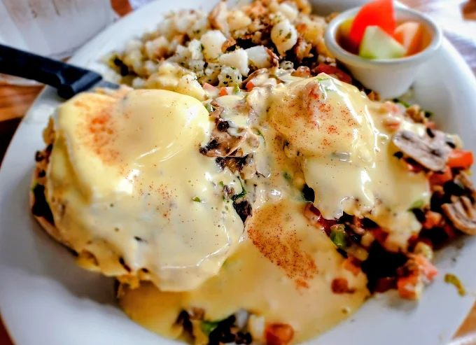 Eggs Benedict smothered in hollandaise with hash